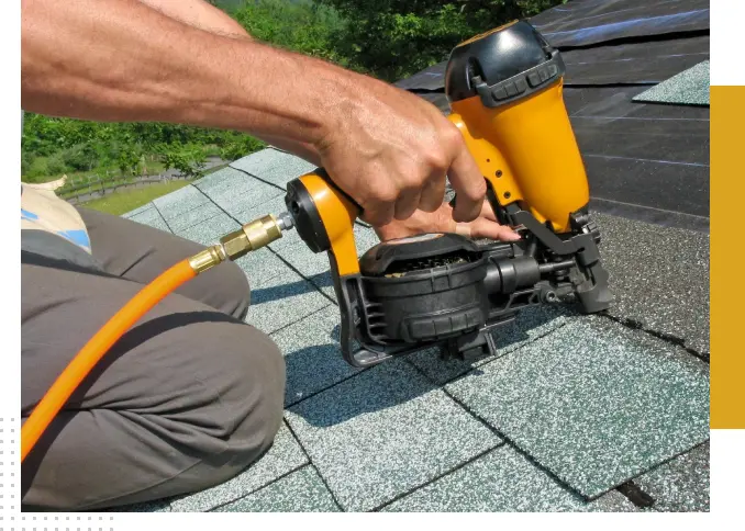 A roofer installing shingles on a roof.