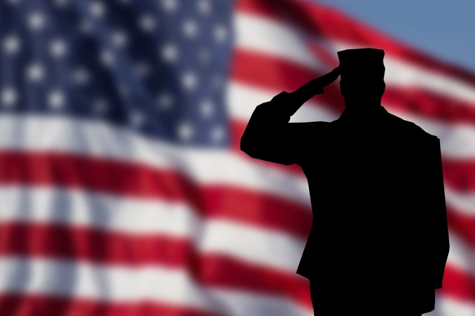 Soldier saluting in front of American flag.